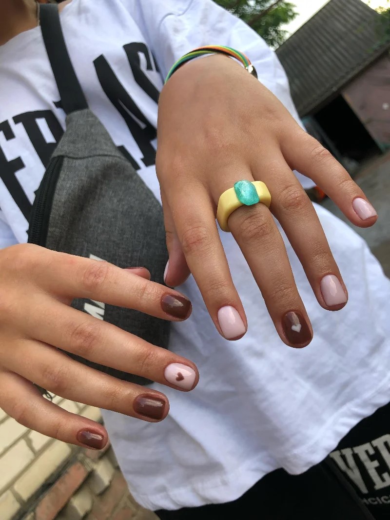 woman wearing a white t-shirt outside showing her BIAB manicure to the camera