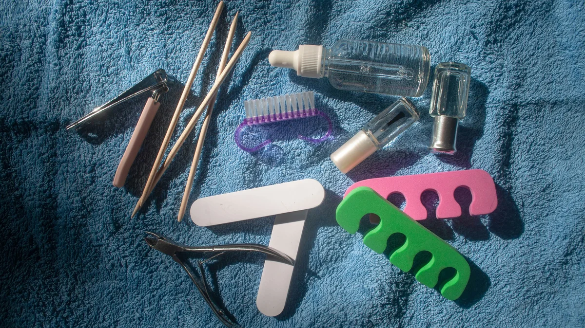 Flat lay of pedicure tools laying on a blue towel