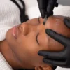 Close-up of an aesthetician performing dermaplaning on a client in salon