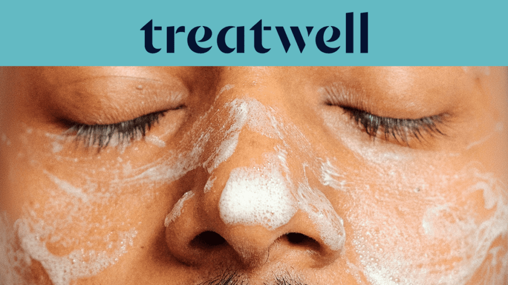 Gros plan du visage d'une personne aux yeux fermés, couvert d'un nettoyant moussant blanc pour le visage. Un bandeau bleu clair en haut affiche le logo "Treatwell" en bleu foncé.