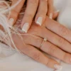 French manucure classique blanche sur des ongles naturels carrés posés sur un tissu blanc