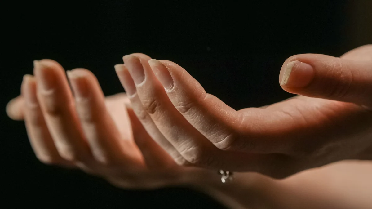 Deux mains tendues, paumes vers le haut, avec des ongles qui se dédoublent