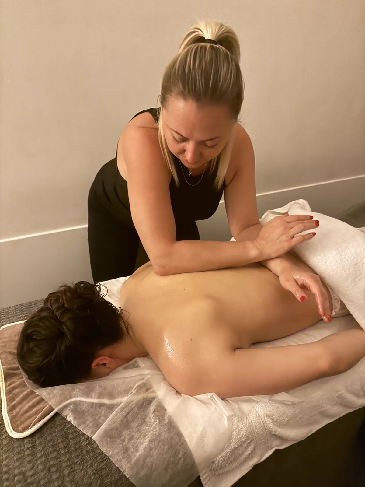 Praticienne réalisant un massage du dos sur une table de soin