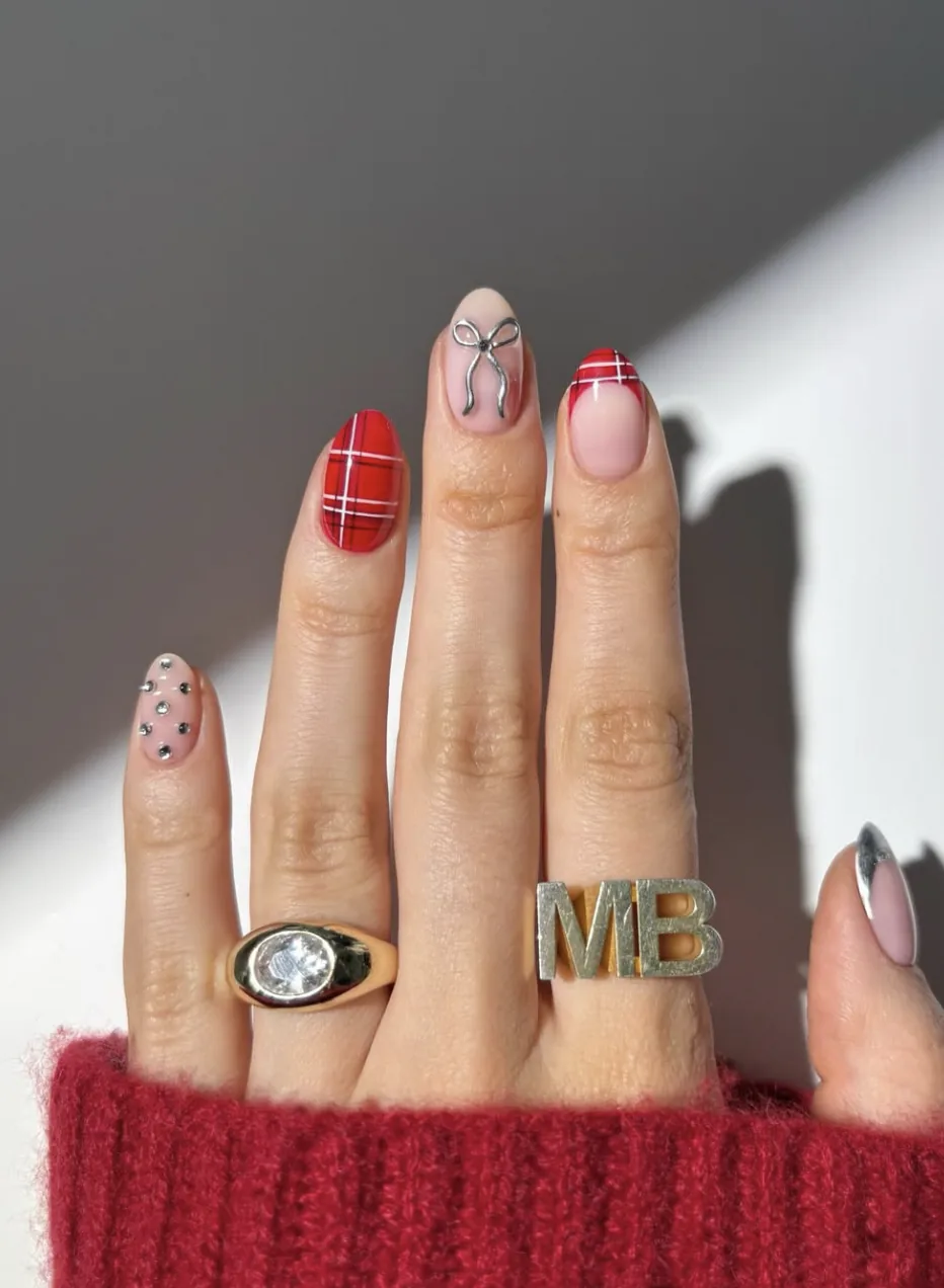 Nail art tartan rouge associé à un motif nœud et à des strass