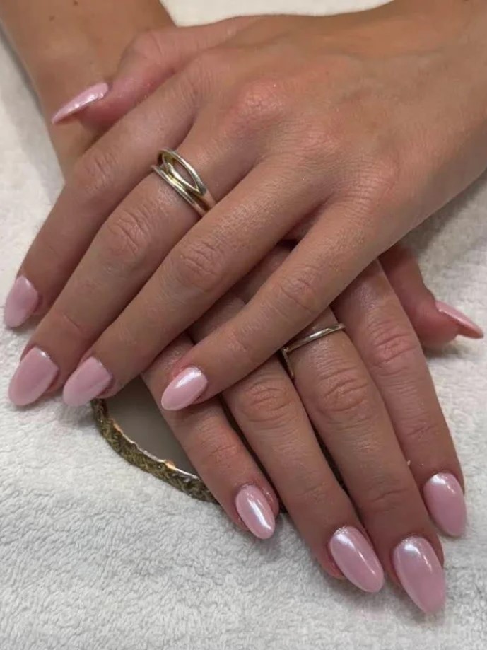 Close-up van een glinsterende roze BIAB-manicure in een salon