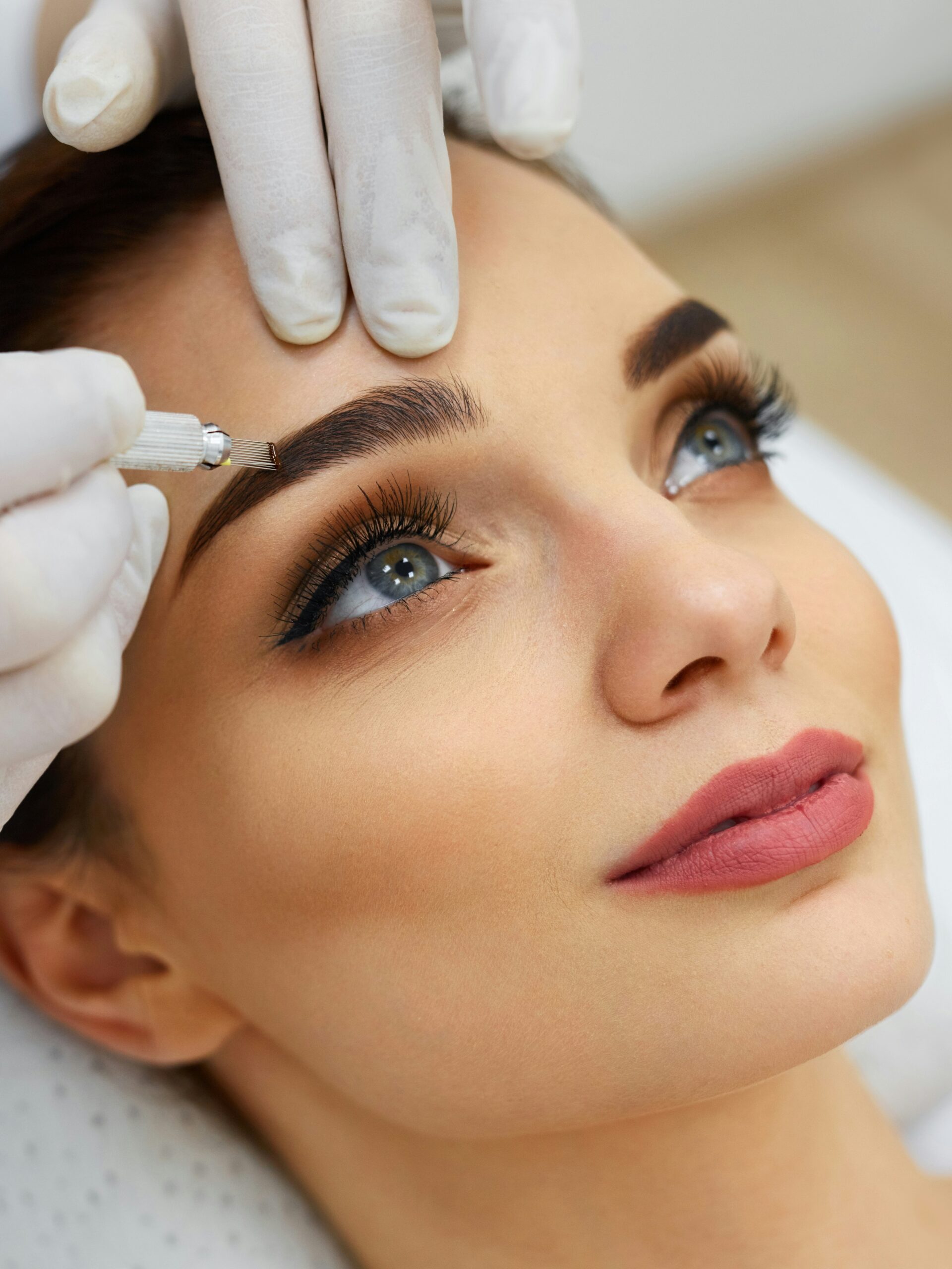 Close-up van het gezicht van een vrouw in een salon die een microbladingbehandeling ondergaat