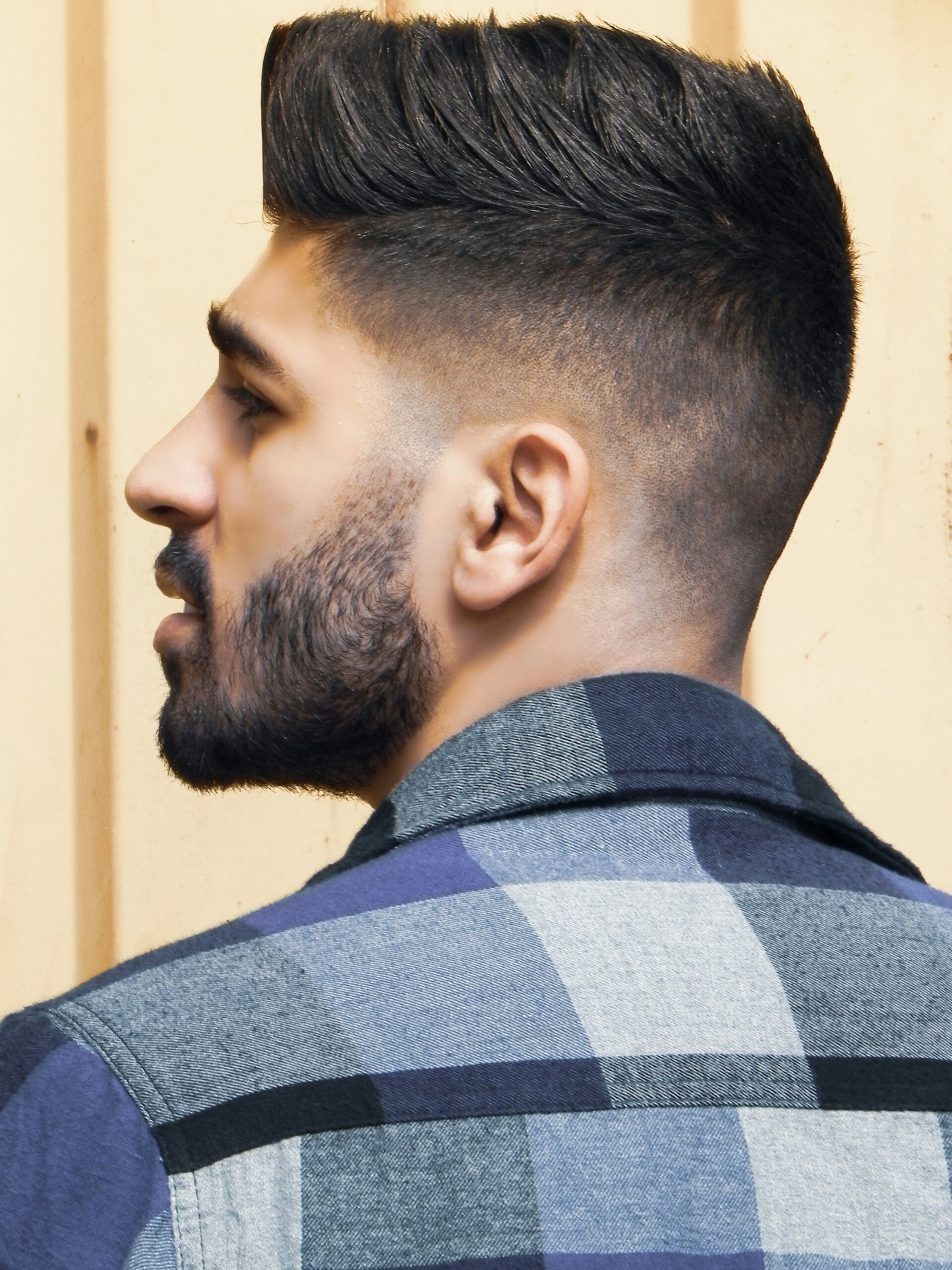 Zijaanzicht van een man met een faux hawk kapsel gecombineerd met een high taper fade
