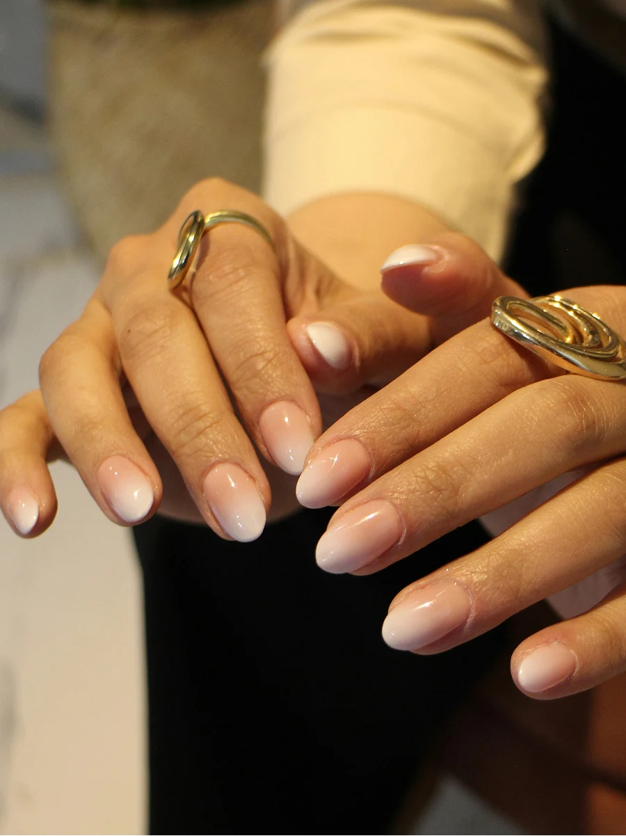Een close-up van een ombré Shellac-manicure van een klant in klassieke nude tinten, direct na de behandeling in de salon