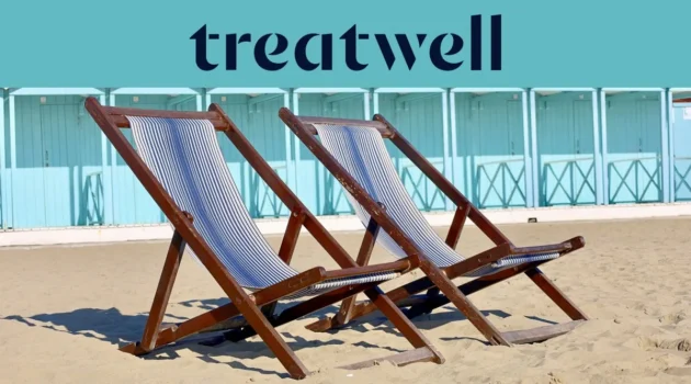 Twee gestreepte houten ligstoelen op het zand voor pastelblauwe strandhuisjes aan de kust van Versilia
