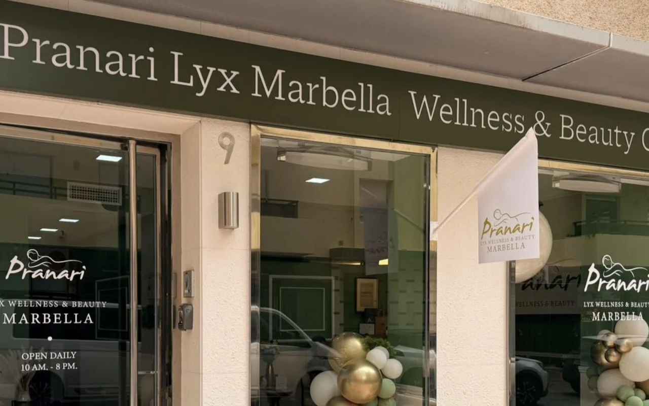 De vestiging van Anchan Massage in Marbella, een wellness- en beautystudio met een groene gevel en wit-gouden ballonnen naast de glazen ingang.