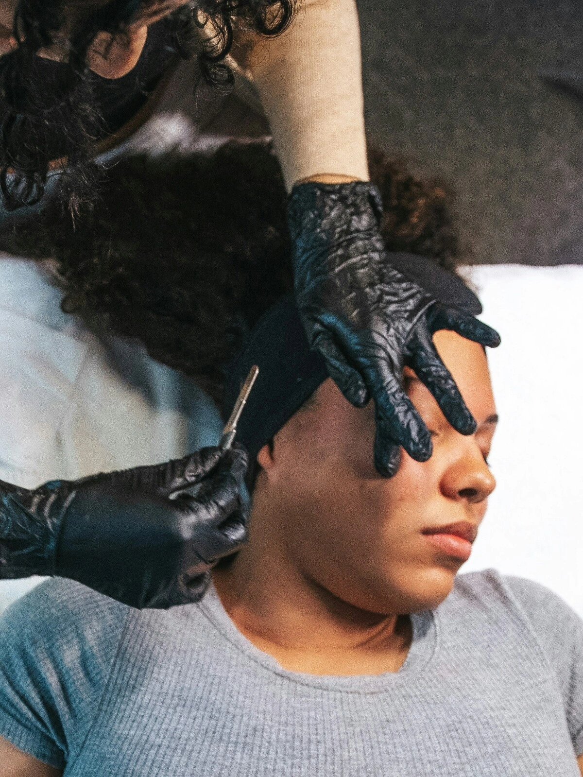 Bovenaanzicht van een schoonheidsspecialist die dermaplaning uitvoert bij een klant in een salon