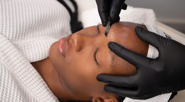 Close-up van een schoonheidsspecialist die dermaplaning uitvoert bij een klant in een salon