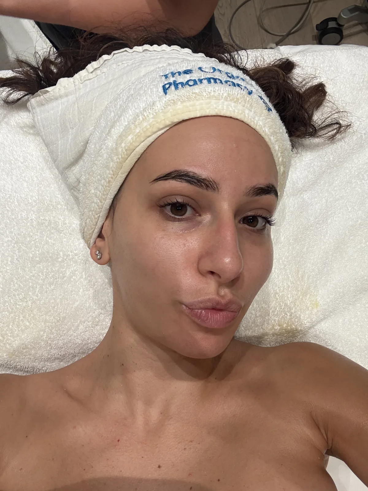 Vrouw met een frisse, stralende huid en een haarband tijdens een gezichtsbehandeling