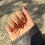 Lava nails met amberkleurige en rode wervelingen op een doorschijnende basis